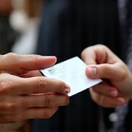 Hands exchanging business cards during a networking session.