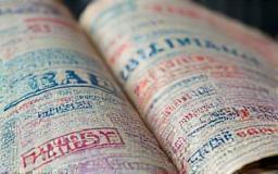 A passport open to pages filled with various visa stamps.